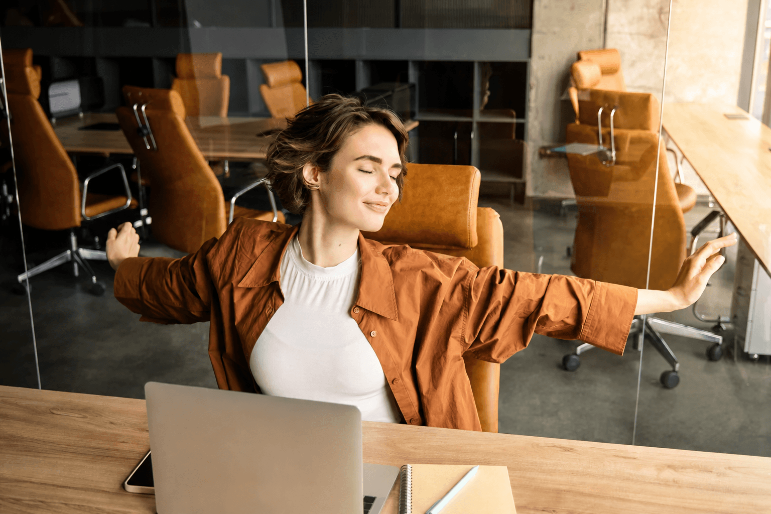Une collaboratrice s’étire, détendue, à son bureau